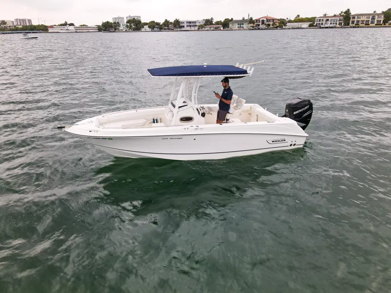 Slide: The Image of 2015 Boston Whaler 220 Outrage boat on water with a person standing. - 5