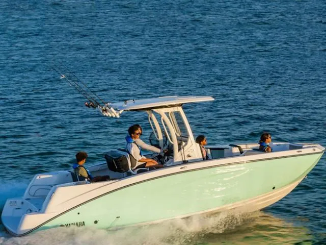 Slide: The Image of 2024 Yamaha Boats 252 FSH Sport cruising on water with passengers. - 1