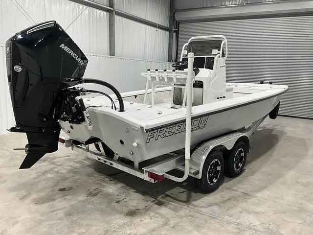 Slide: The Image of 2024 Freedom Boats 23' Warrior with Mercury outboard engine in a garage. - 3