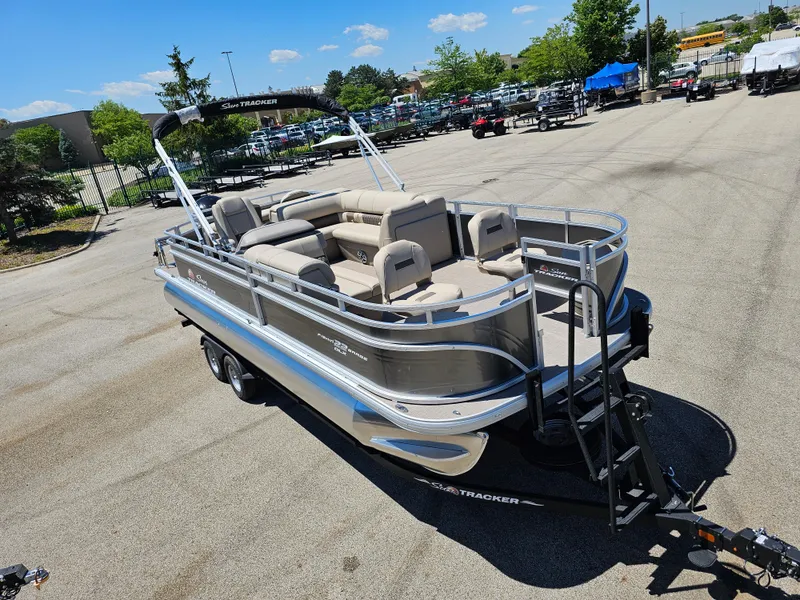 Slide: The Image of 2024 Sun Tracker Fishin' Barge 22 DLX pontoon boat in a parking lot. - 3
