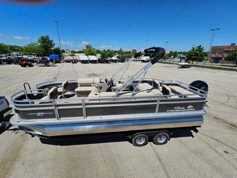 Slide: The Image of 2024 Sun Tracker Fishin' Barge 22 DLX pontoon boat in a parking lot. - 5