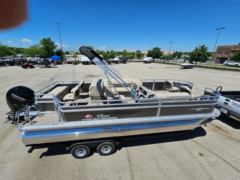 Slide: The Image of 2024 Sun Tracker Fishin' Barge 22 DLX pontoon boat in a parking lot. - 6