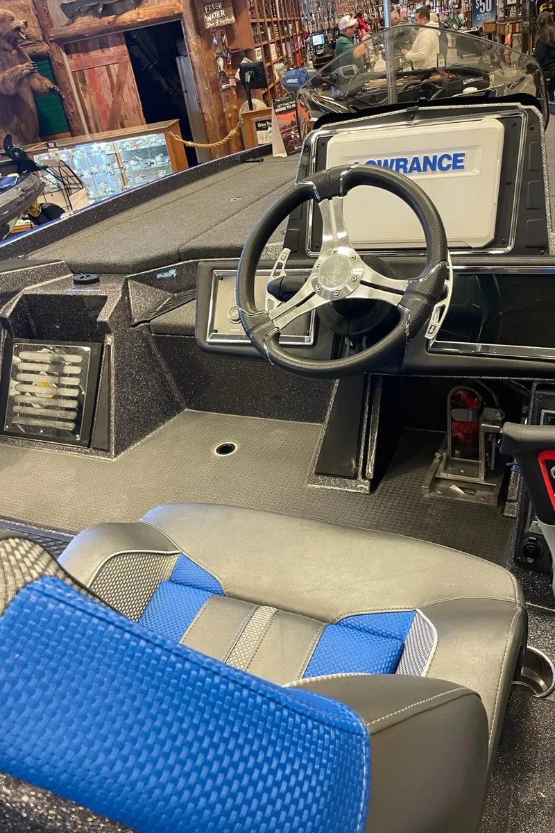 Slide: The Image of 2024 Ranger Z521R boat interior with steering wheel and blue-accented seat. - 3