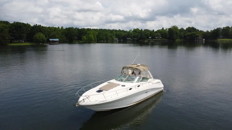 Slide: The Image of 2003 Sea Ray 340 Sundancer cruising on a serene lake. - 7