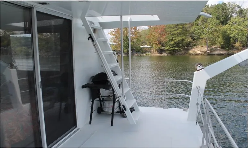 Slide: The Image of 1995 Pluckebaum Coastal Cruiser deck with stairs, grill, and lake view. - 11