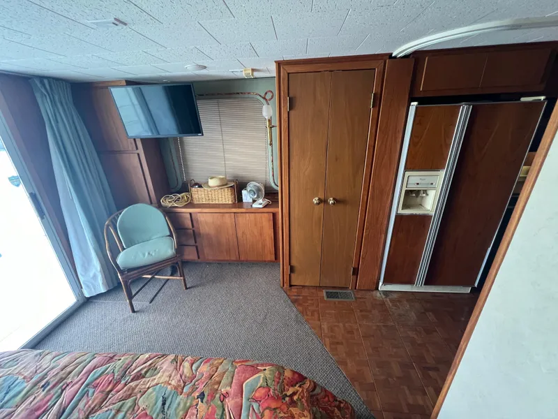 Slide: The Image of Interior of 1995 Pluckebaum Coastal Cruiser with wood paneling, TV, chair, and refrigerator. - 22