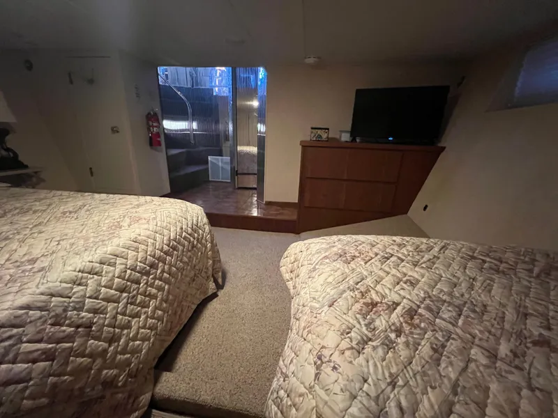 Slide: The Image of Interior of a 1995 Pluckebaum Coastal Cruiser bedroom with twin beds and a TV. - 26