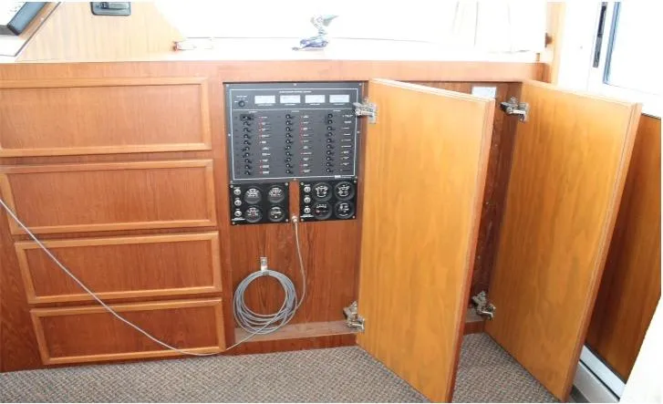 Slide: The Image of Electrical panel inside a 1995 Pluckebaum Coastal Cruiser with open wooden cabinet doors. - 27