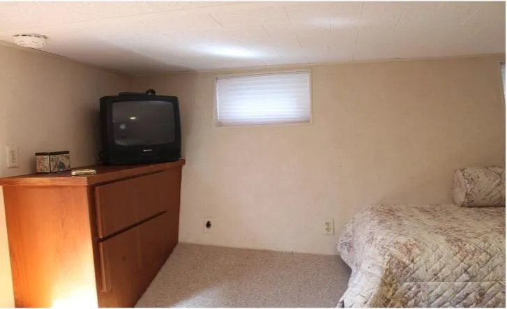 Slide: The Image of 1995 Pluckebaum Coastal Cruiser interior bedroom with TV and wooden dresser. - 29