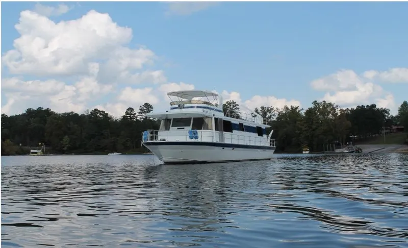 Slide: The Image of 1995 Pluckebaum Coastal Cruiser on a serene lake with a forested shoreline. - 3