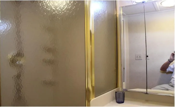 Slide: The Image of Bathroom in a 1995 Pluckebaum Coastal Cruiser with gold-framed shower and mirrored cabinet. - 31