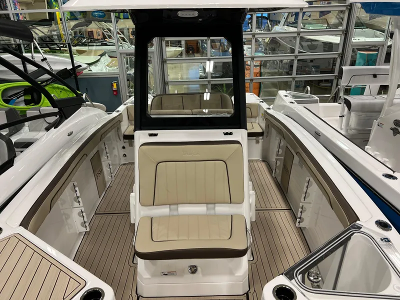 Slide: The Image of 2024 Yamaha Boats 255 FSH Sport H interior, featuring beige seating and spacious deck. - 7