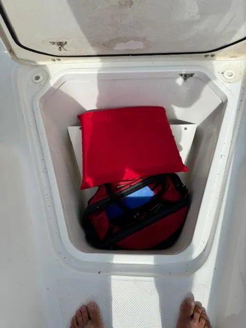 Slide: The Image of Storage compartment on a 2013 Sea Fox 286 CC boat with red cushion and bag. - 10