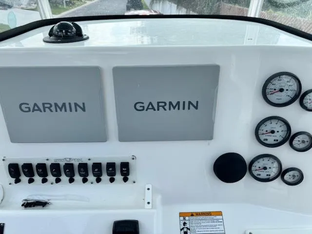 Slide: The Image of 2013 Sea Fox 286 CC boat dashboard with Garmin displays and gauges. - 13