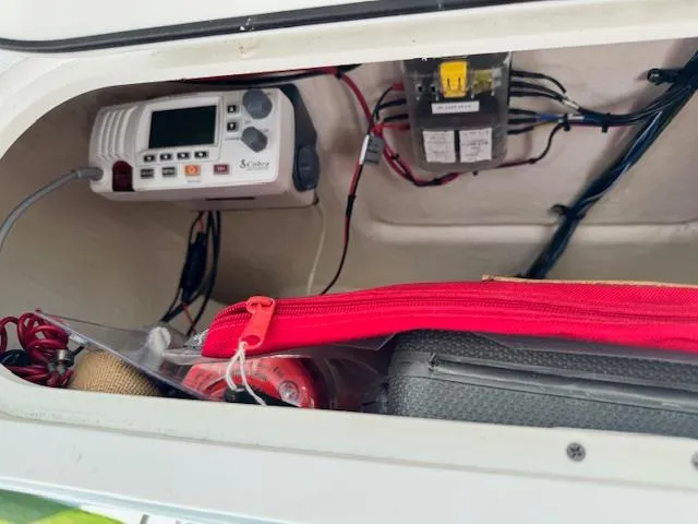 Slide: The Image of 2013 Sea Fox 286 CC storage compartment with electronic equipment and red zippered bag. - 17