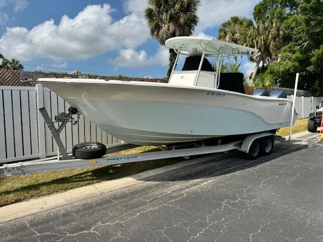 Slide: The Image of 2013 Sea Fox 286 CC boat on a trailer, parked near a white fence. - 4