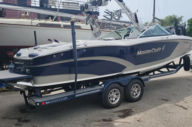 Slide: The Image of 2016 MasterCraft X26 boat on a trailer in a marina. - 1