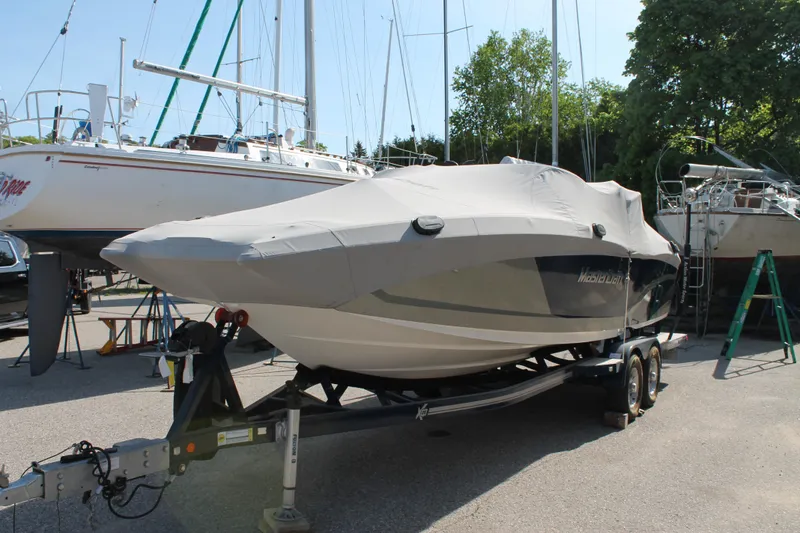 Slide: The Image of 2016 MasterCraft X26 boat on a trailer, covered and parked in a marina. - 11