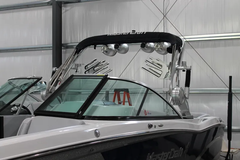 Slide: The Image of 2016 MasterCraft X26 boat in storage, featuring sleek design and modern wakeboard tower. - 2