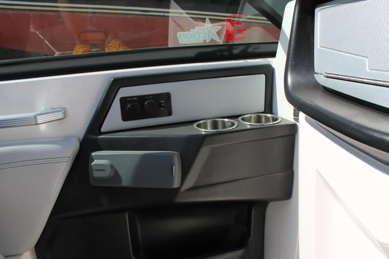 Slide: The Image of 2016 MasterCraft X26 boat interior door panel with cup holders and controls. - 23