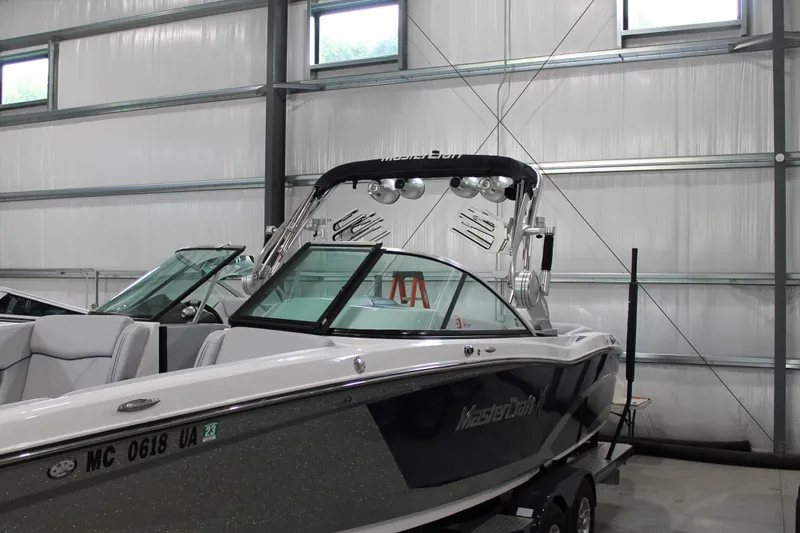Slide: The Image of 2016 MasterCraft X26 boat in indoor storage, featuring sleek design and modern amenities. - 3