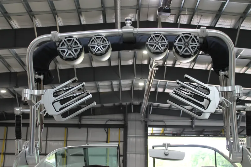 Slide: The Image of 2016 MasterCraft X26 wakeboard tower with speakers and board racks in a warehouse. - 8