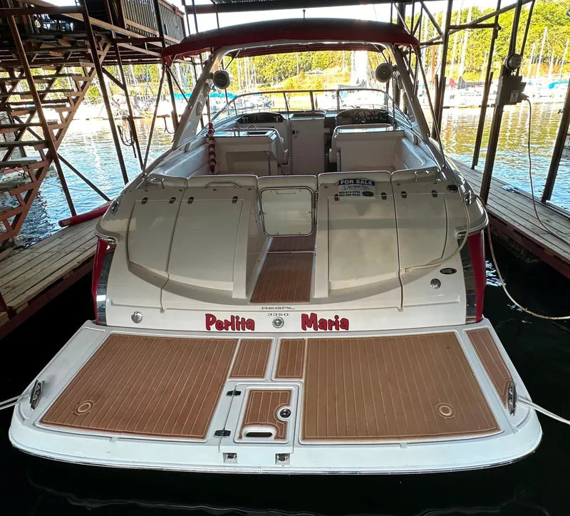 Slide: The Image of 2005 Regal 3350 Sport Cruiser docked, rear view with wooden deck and marina background. - 12