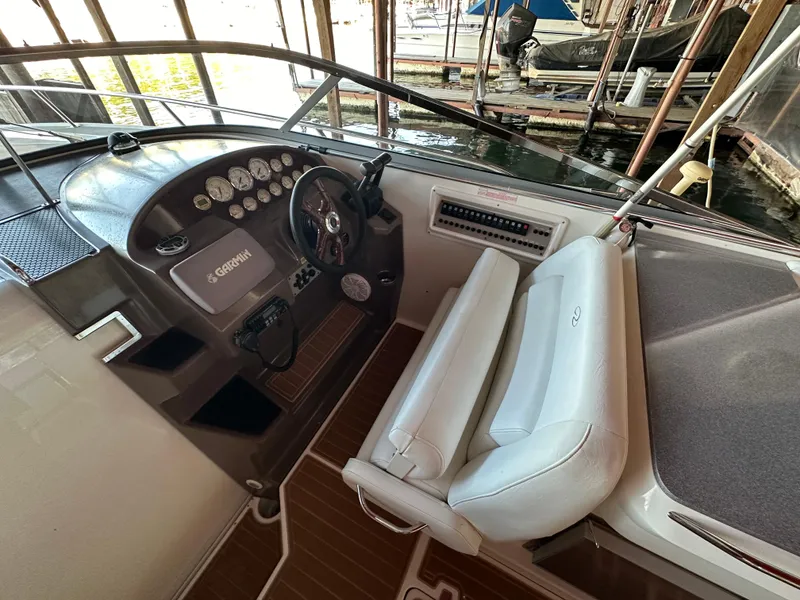 Slide: The Image of 2005 Regal 3350 Sport Cruiser helm with steering wheel and gauges, docked in marina. - 14