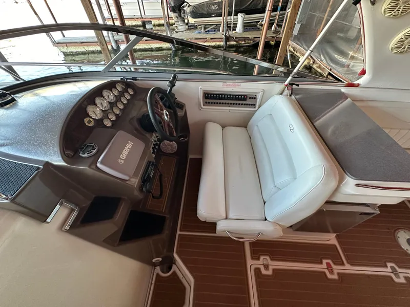 Slide: The Image of 2005 Regal 3350 Sport Cruiser cockpit with white seating and wooden flooring. - 15