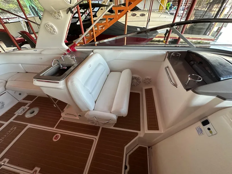 Slide: The Image of 2005 Regal 3350 Sport Cruiser interior with white seating and wood-patterned flooring. - 18