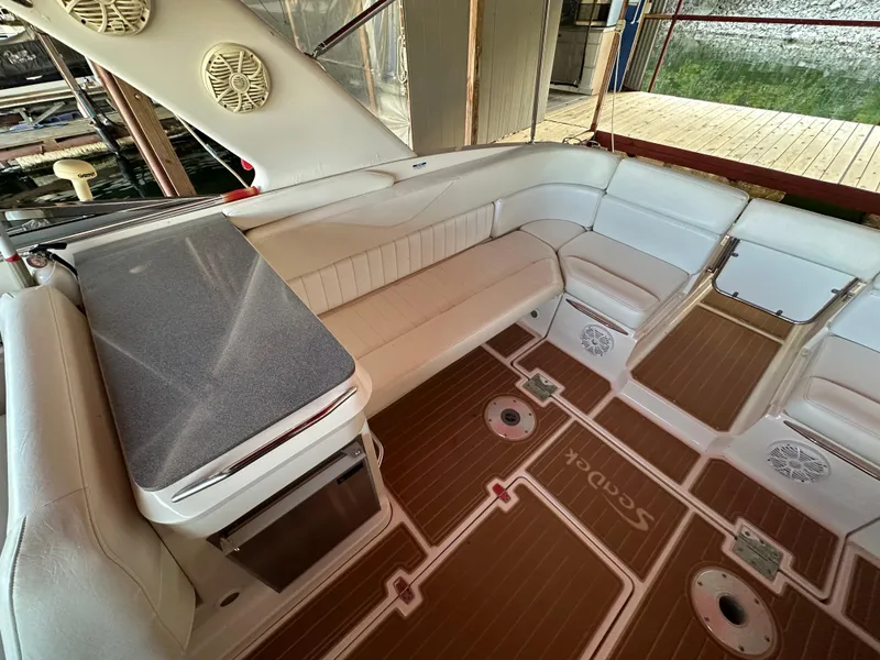 Slide: The Image of 2005 Regal 3350 Sport Cruiser interior with white seating and wood-patterned flooring. - 21