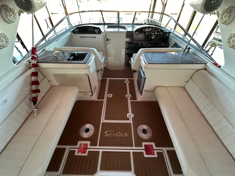Slide: The Image of 2005 Regal 3350 Sport Cruiser interior with white seating and wood-style flooring. - 23