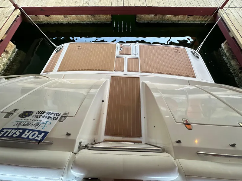 Slide: The Image of 2005 Regal 3350 Sport Cruiser docked, featuring teak deck and "For Sale" sign. - 24