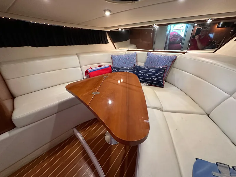 Slide: The Image of Interior of 2005 Regal 3350 Sport Cruiser with white seating and wooden table. - 29