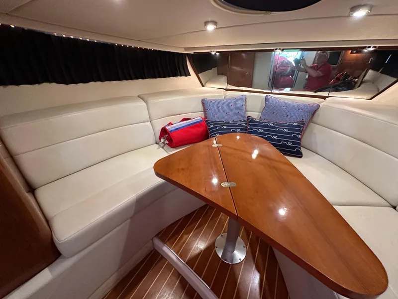 Slide: The Image of Interior of 2005 Regal 3350 Sport Cruiser with white leather seating and wooden table. - 30