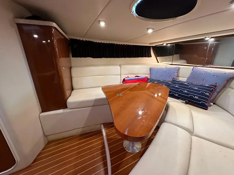 Slide: The Image of Interior of 2005 Regal 3350 Sport Cruiser with wooden table and cushioned seating. - 31