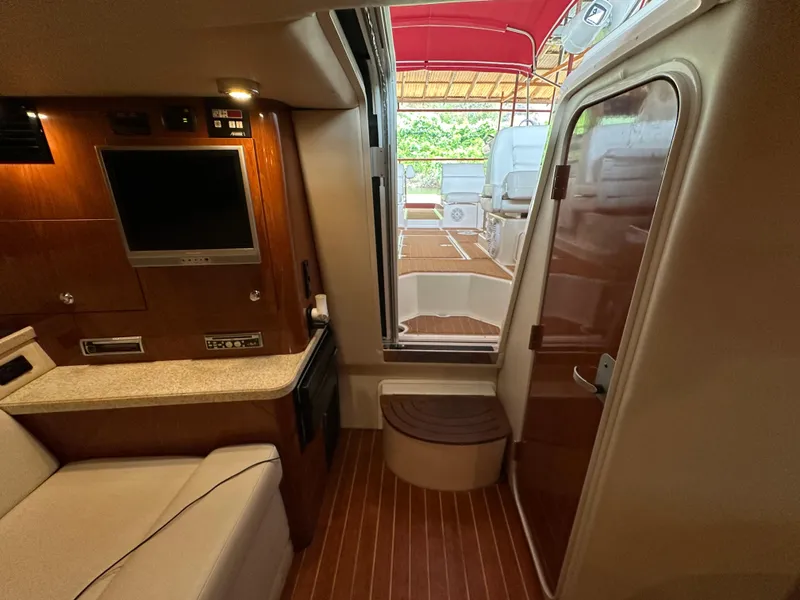 Slide: The Image of Interior of 2005 Regal 3350 Sport Cruiser with TV, seating, and wooden flooring. - 32
