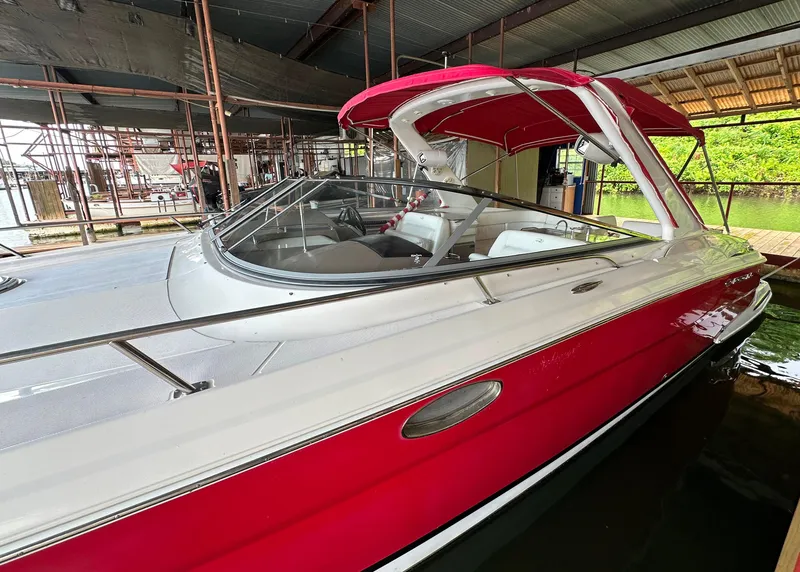 Slide: The Image of 2005 Regal 3350 Sport Cruiser with red and white exterior docked in a covered marina. - 5