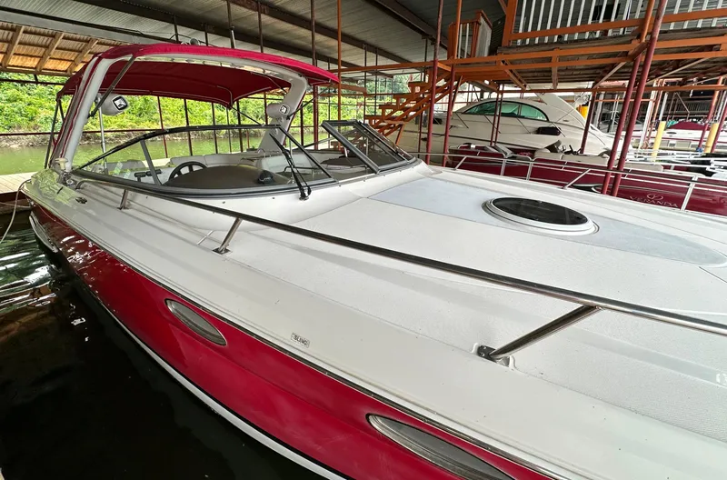 Slide: The Image of 2005 Regal 3350 Sport Cruiser with red and white exterior docked in a covered marina. - 6