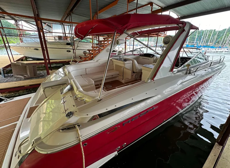 Slide: The Image of 2005 Regal 3350 Sport Cruiser with red canopy docked in a marina. - 7