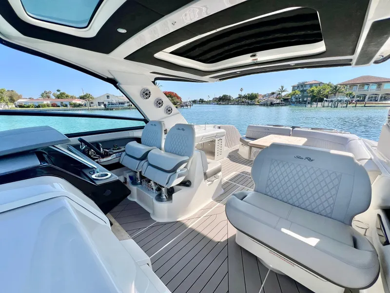 Slide: The Image of 2022 Sea Ray SLX 400 OB luxury boat interior with plush seating and waterfront view. - 12