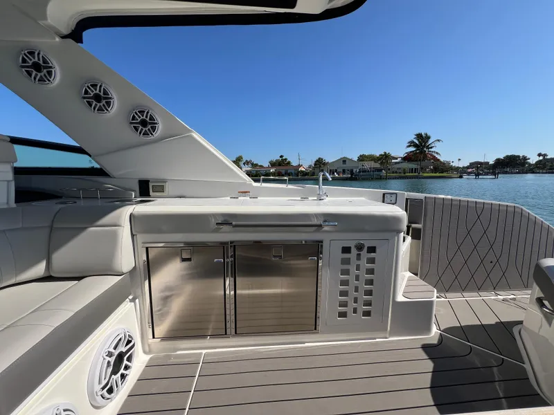 Slide: The Image of 2022 Sea Ray SLX 400 OB boat interior with stainless steel appliances and waterfront view. - 9