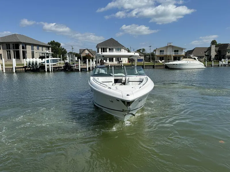 Slide: The Image of 2025 Regal 3300 boat cruising in a residential canal under a clear blue sky. - 4