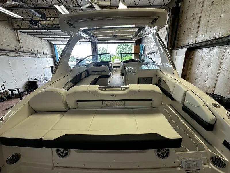 Slide: The Image of 2025 Regal 3300 boat interior with white seating and modern design in a warehouse. - 7