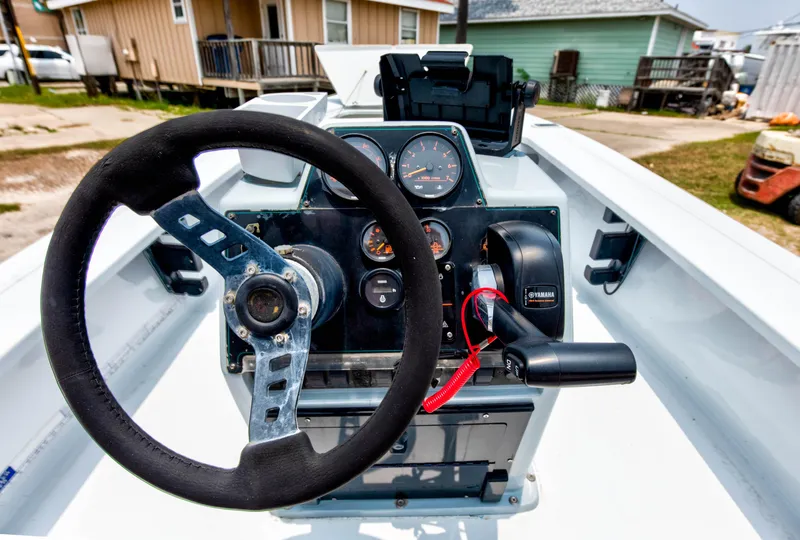 Slide: The Image of 1996 Hewes Tunnel boat dashboard with steering wheel and control panel. - 11