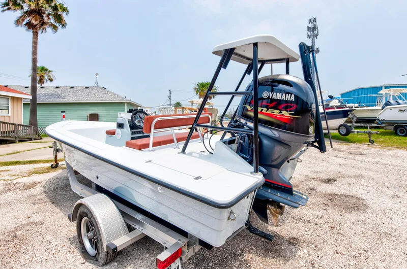 Slide: The Image of 1996 Hewes Tunnel boat with Yamaha outboard motor on trailer in a coastal setting. - 4