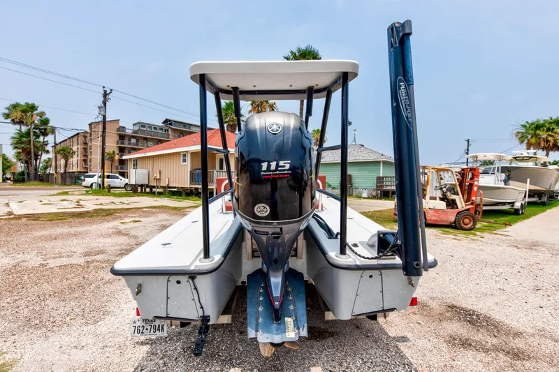 Slide: The Image of 1996 Hewes Tunnel boat with Yamaha 115 outboard motor, parked on gravel lot. - 5