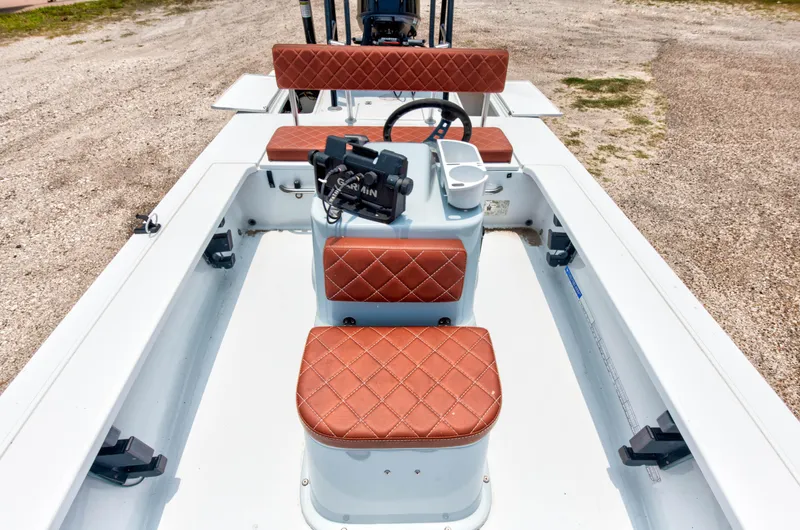 Slide: The Image of 1996 Hewes Tunnel boat interior with brown diamond-stitched seats and steering console. - 8