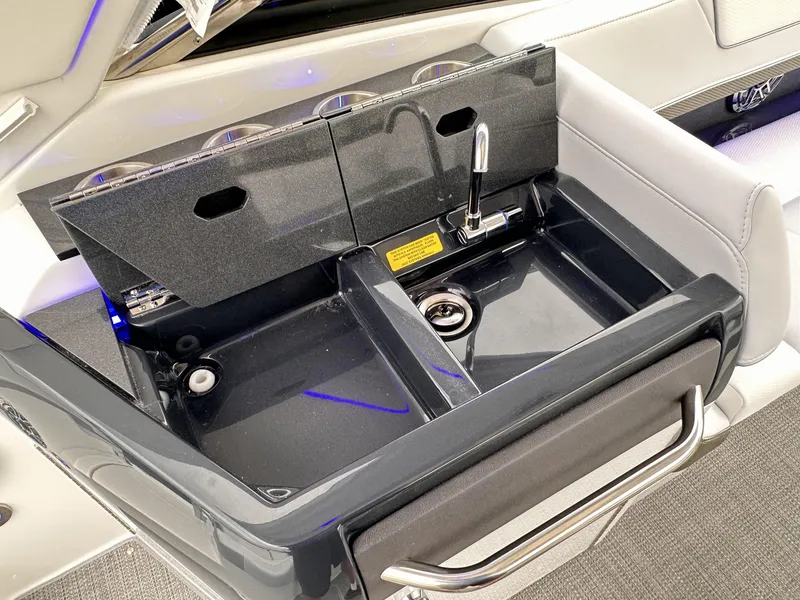 Slide: The Image of 2024 Formula 310 Bowrider I/O boat sink with faucet and storage compartments. - 16