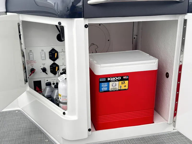 Slide: The Image of 2024 Formula 310 Bowrider I/O storage compartment with red Igloo cooler and control panel. - 15